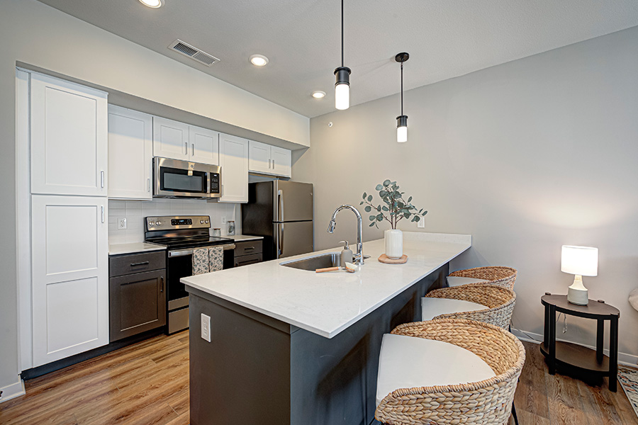 Kitchen island with seating and overhead lights at an upscale apartment